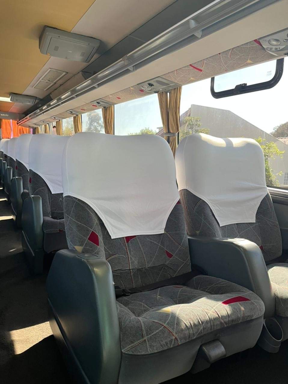 Interior de ônibus com poltronas e janelas